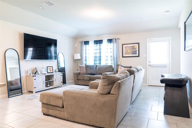 living room with lofted ceiling, a healthy amount of sunlight, and light tile patterned floors