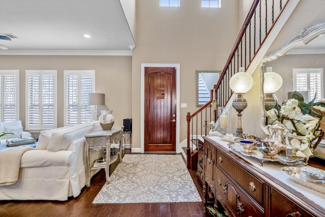 foyer entrance with ornamental molding and dark hardwood / wood-style floors