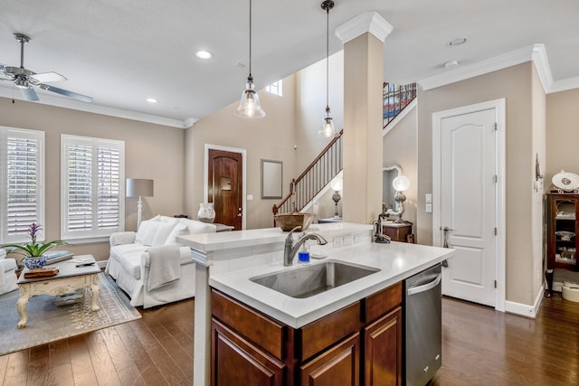 kitchen featuring dishwasher, sink, hanging light fixtures, a kitchen island with sink, and crown molding