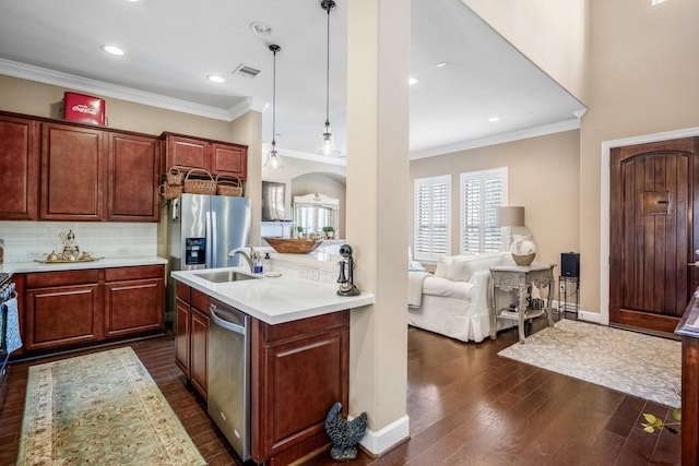 kitchen featuring sink, decorative light fixtures, appliances with stainless steel finishes, dark hardwood / wood-style flooring, and backsplash