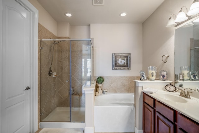 bathroom featuring vanity and independent shower and bath