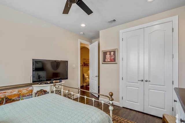 bedroom with dark hardwood / wood-style flooring, a closet, and ceiling fan