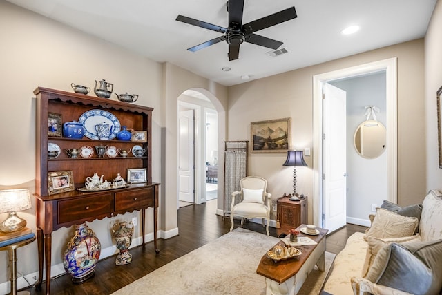 living area with ceiling fan and dark hardwood / wood-style flooring