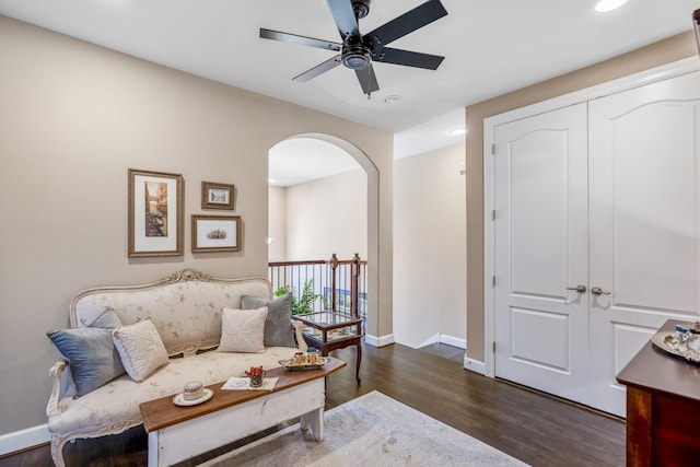 living area featuring dark wood-type flooring and ceiling fan