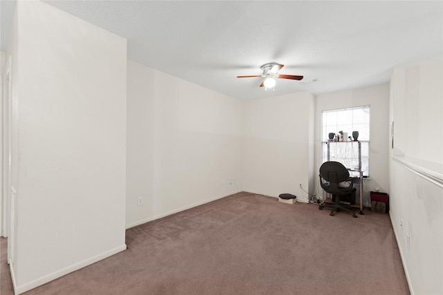 unfurnished office featuring ceiling fan and light carpet