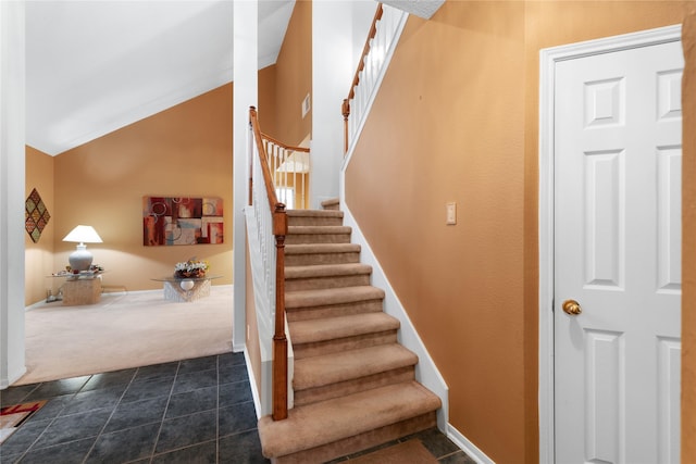 stairs with vaulted ceiling and carpet floors