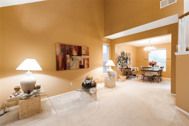 interior space with a high ceiling, a chandelier, and carpet flooring