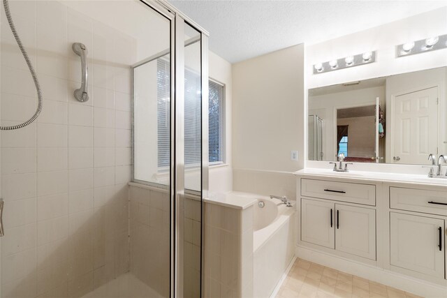 bathroom featuring vanity, shower with separate bathtub, and a textured ceiling