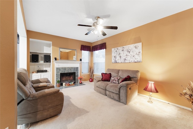 carpeted living room with ceiling fan and a fireplace