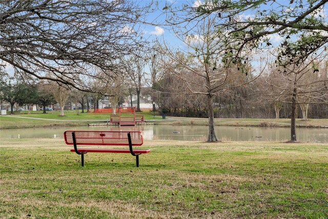 view of community featuring a water view and a lawn