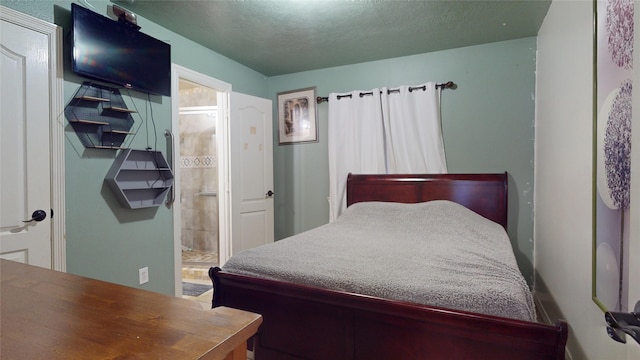 bedroom featuring a textured ceiling and ensuite bath