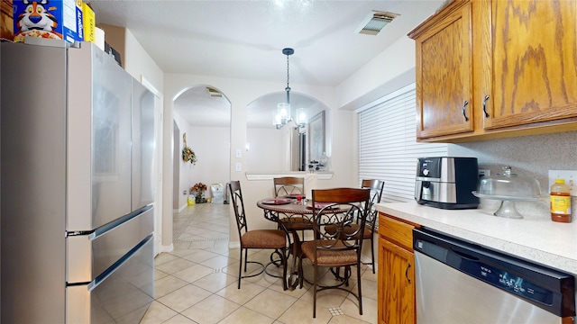 kitchen with pendant lighting, light tile patterned floors, and stainless steel appliances