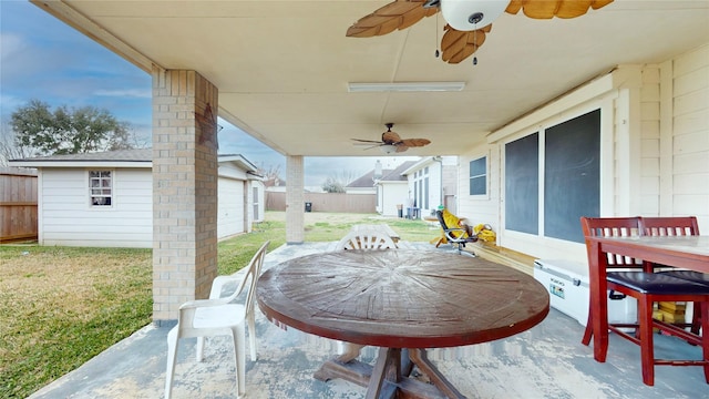 view of patio featuring a garage, an outdoor structure, and ceiling fan