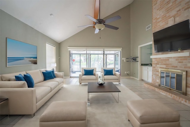 living room featuring a brick fireplace, high vaulted ceiling, ceiling fan, and light tile patterned flooring