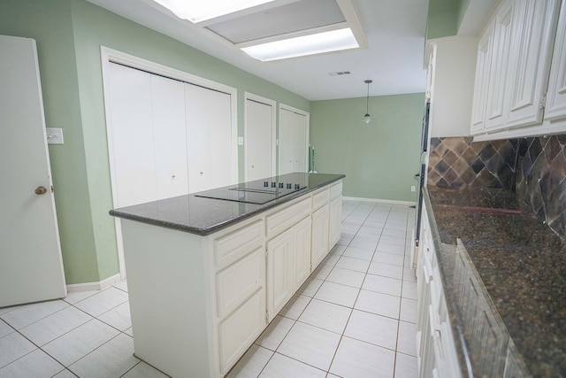 kitchen featuring black electric cooktop, white cabinetry, dark stone counters, and light tile patterned floors