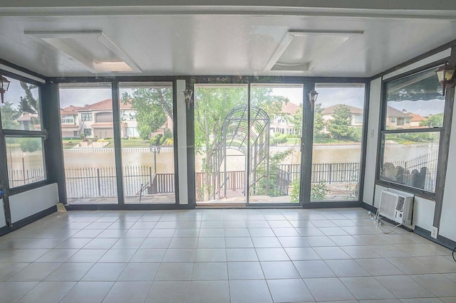 unfurnished sunroom with a water view, plenty of natural light, and a wall mounted air conditioner