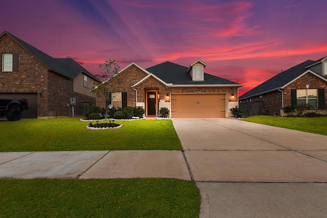 view of front of home featuring driveway, roof with shingles, an attached garage, a front lawn, and brick siding