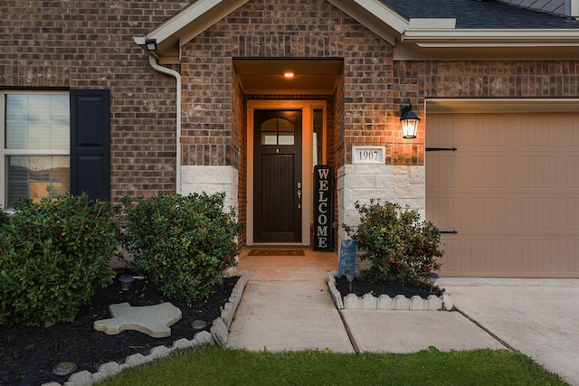 view of exterior entry featuring brick siding, roof with shingles, and an attached garage