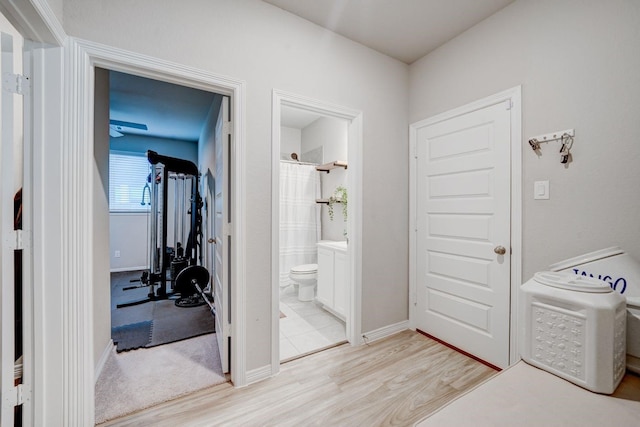 interior space featuring toilet, curtained shower, and hardwood / wood-style floors