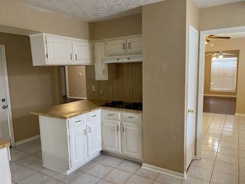 kitchen with kitchen peninsula, a textured ceiling, and white cabinets