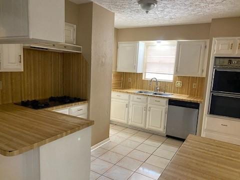 kitchen featuring sink, black appliances, white cabinets, and light tile patterned flooring