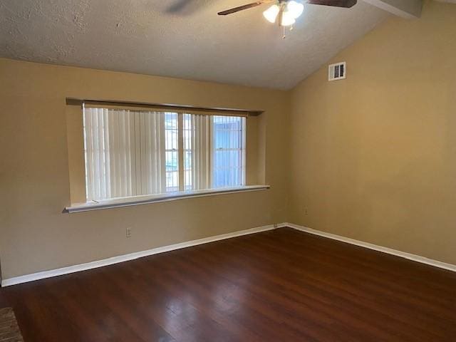 spare room with dark hardwood / wood-style flooring, ceiling fan, lofted ceiling with beams, and a textured ceiling