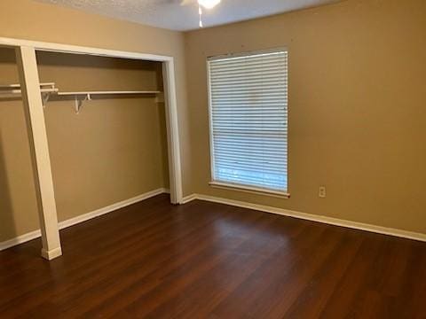 unfurnished bedroom featuring a textured ceiling, dark wood-type flooring, and ceiling fan