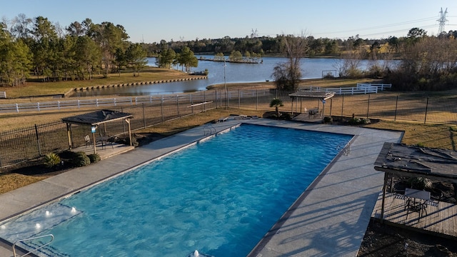 view of swimming pool with a yard and a water view