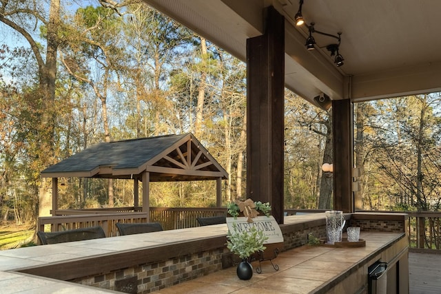 view of patio featuring a deck, a gazebo, and a bar