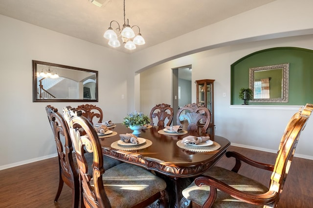 dining space featuring dark wood-type flooring and a chandelier