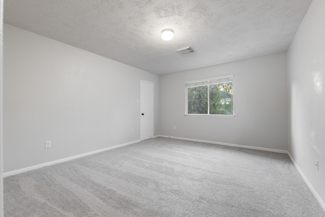 carpeted spare room featuring a textured ceiling