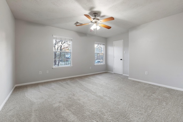 carpeted spare room with a textured ceiling and ceiling fan