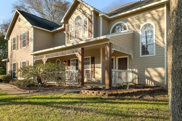 view of front of house with covered porch and a front yard