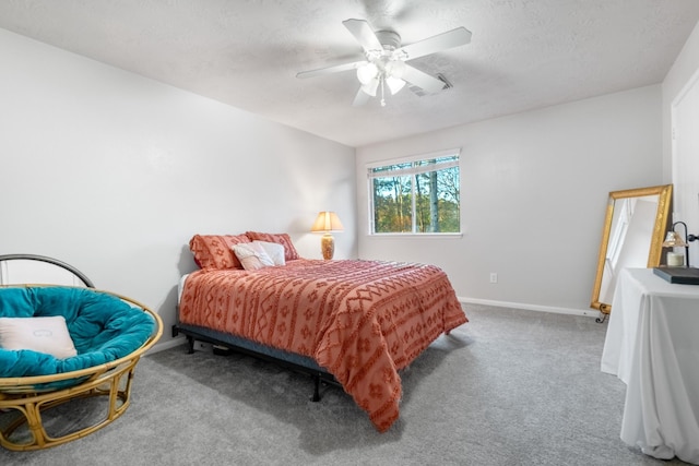 bedroom featuring ceiling fan, carpet floors, and a textured ceiling