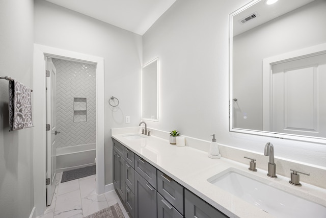 bathroom with vanity and tiled shower / bath