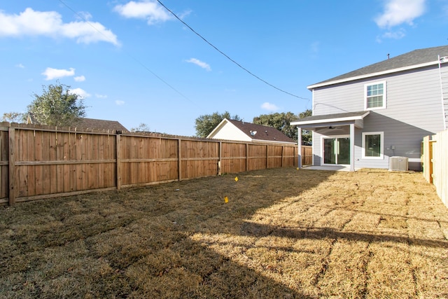 back of house featuring central AC unit and a lawn