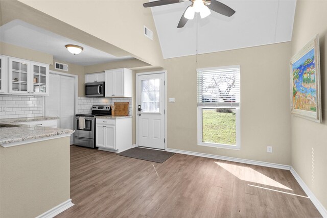 410 Indian Shr, Livingston, TX 77351 - kitchen with appliances with stainless steel finishes, dark wood-type flooring, tasteful backsplash, white cabinets, and glass insert cabinets