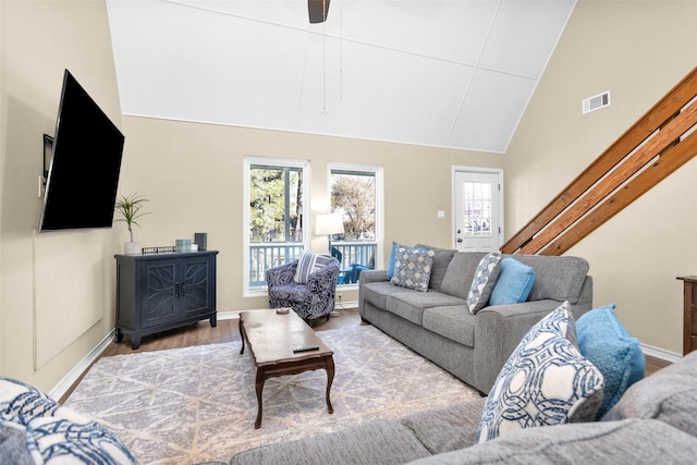 living room with wood-type flooring and high vaulted ceiling