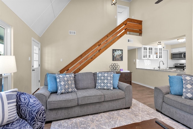 living room featuring hardwood / wood-style flooring and high vaulted ceiling