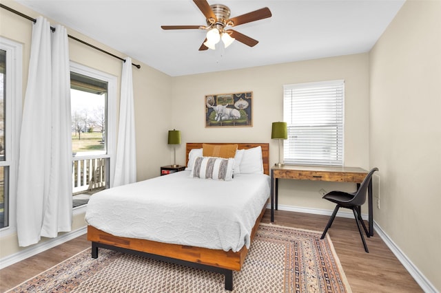 bedroom with ceiling fan, access to outside, and wood-type flooring