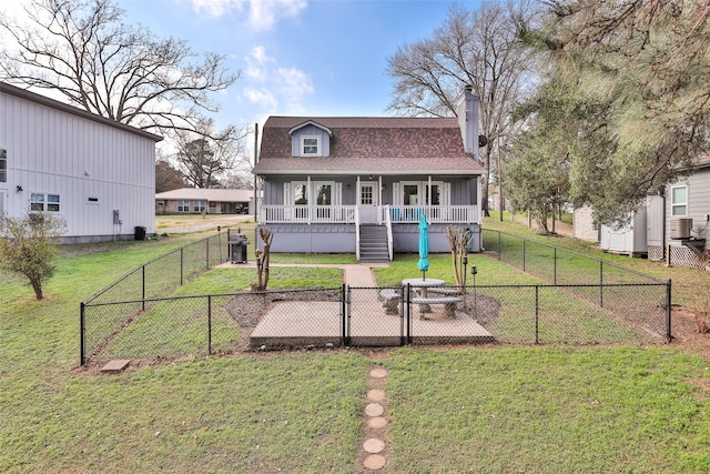 rear view of property with cooling unit, a yard, and covered porch