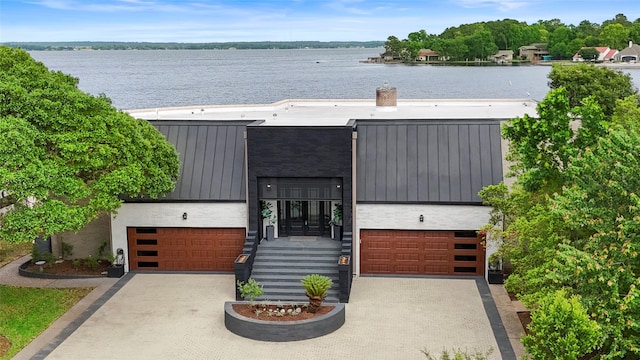 view of front of property featuring a garage and a water view