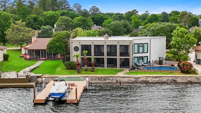 back of property featuring a water view and a yard