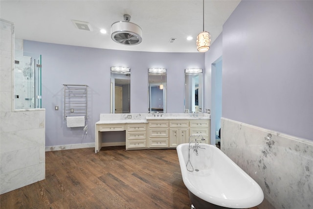 bathroom featuring a washtub, vanity, hardwood / wood-style flooring, and tile walls