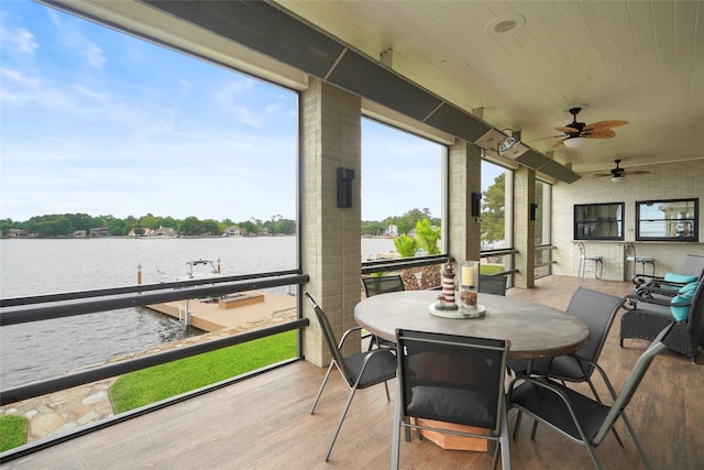 sunroom / solarium featuring wood ceiling and a water view