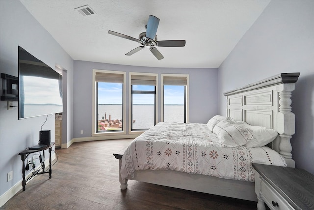 bedroom with a textured ceiling, wood-type flooring, and ceiling fan