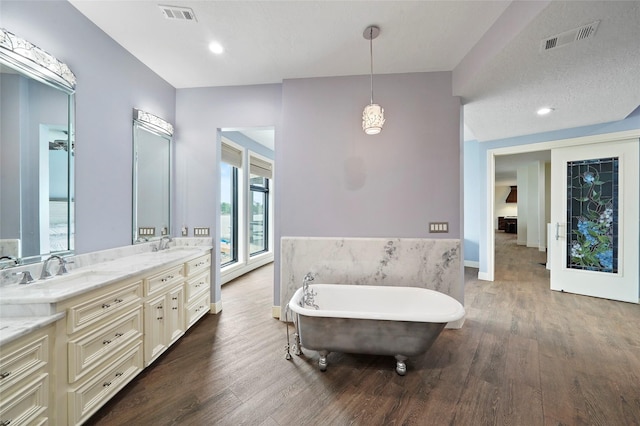 bathroom featuring wood-type flooring, a bathtub, and vanity