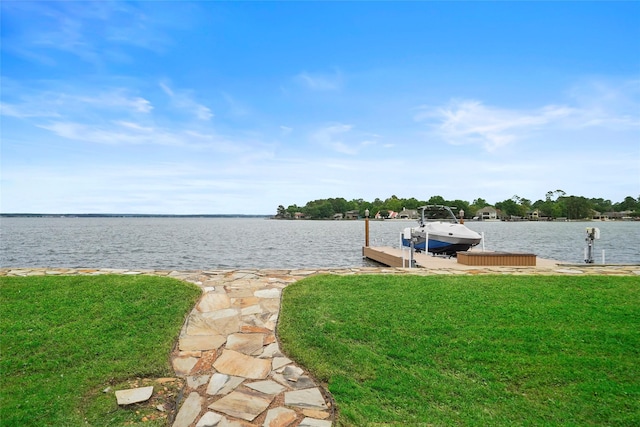 dock area featuring a lawn and a water view