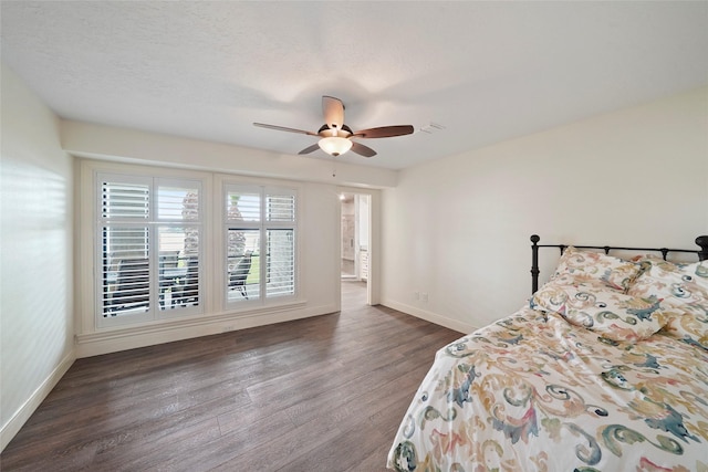 bedroom featuring ceiling fan, dark hardwood / wood-style floors, and a textured ceiling