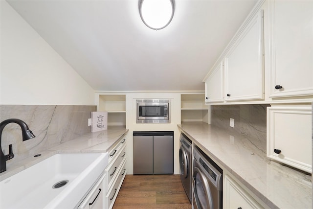 kitchen with sink, white cabinetry, separate washer and dryer, stainless steel microwave, and dark hardwood / wood-style flooring